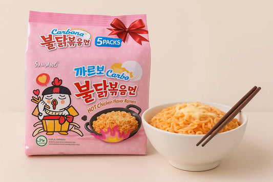 Samyang Carbonara Spicy Chicken Ramen 5-pack with pink packaging and cartoon chicken placed beside a steaming bowl of creamy ramen topped with cheese and chopsticks. Premium Seoul Oasis UAE lifestyle food image with realistic lighting.