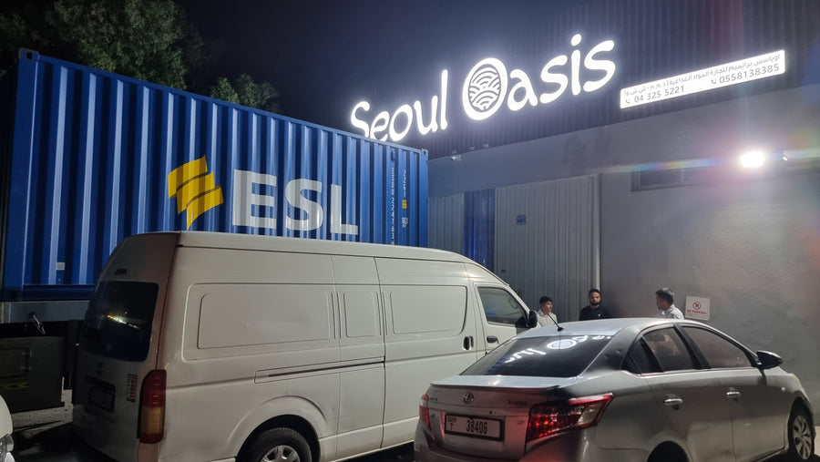 The Seoul Oasis facility at night with a branded delivery van and shipping container
